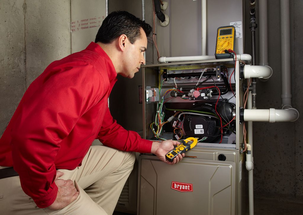 Heating and air conditioning technician servicing an indoor furnace in Mesa, AZ