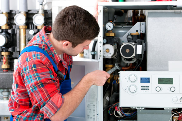 HVAC technician inspecting an indoor heating system in Mesa, AZ