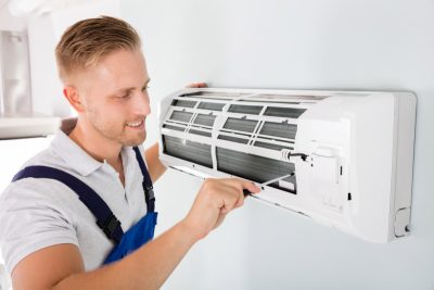 HVAC technician cleaning and repairing a ductless mini split AC in Mesa, AZ