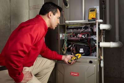 Heating and air conditioning technician servicing an indoor furnace in Mesa, AZ